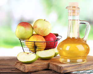 Apple cider vinegar in glass bottle and ripe fresh apples,