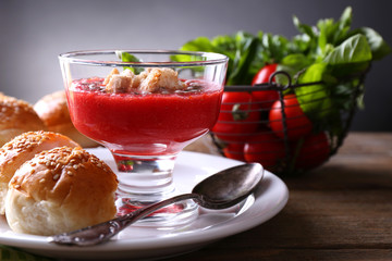 Gazpacho soup in glass bowl, on color wooden background