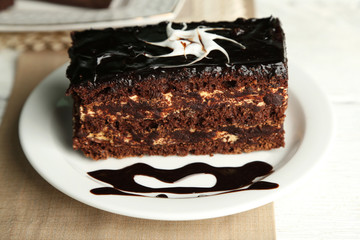 Chocolate cake on plate, on wooden background