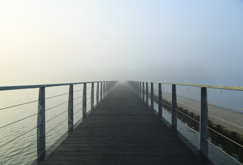 Empty footbridge in the morning fog.