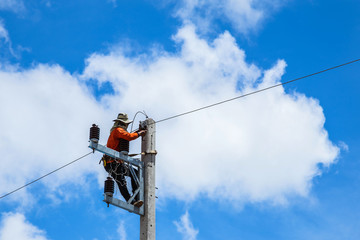 electrician working  repairing wire on electric power pole