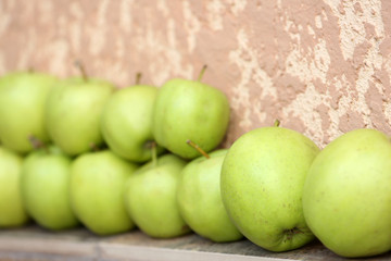 Juicy apples in row on wall background