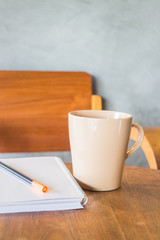 Beautiful wooden work table with cup of coffee