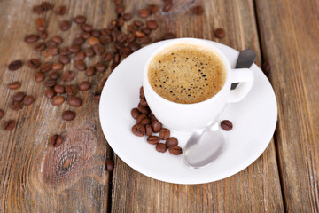 Cup of coffee with milk and coffee beans on wooden background