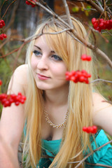 Portrait of a beautiful girl near the red viburnum