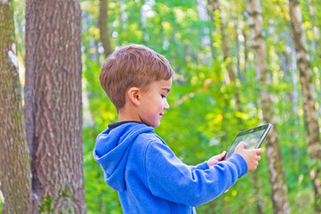 child in the woods with the tablet pc