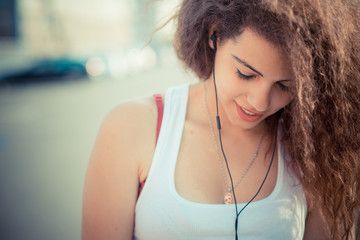 young beautiful long curly hair hipster woman listening music