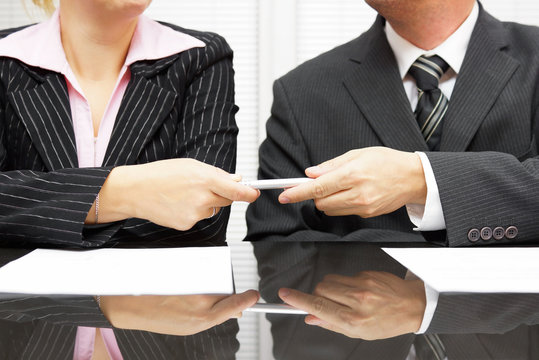 businessman is giving pen to business partner to sign contract