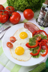Scrambled eggs with bacon and vegetables served