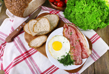 Scrambled eggs with bacon and vegetables served
