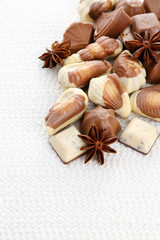Obraz na płótnie Canvas Different kinds of chocolates with spices on white background