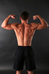 Fototapeta premium Handsome muscle young man on dark background