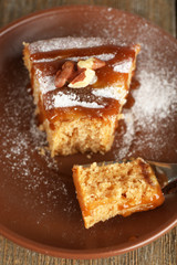 Half eaten delicious cake piece on plate on wooden table