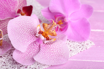 Obraz na płótnie Canvas Pink tropical orchid flowers on color wooden background