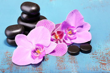 Fototapeta na wymiar Pink tropical orchid flowers and spa stones