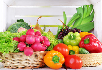 Vegetables in baskets on white wooden box background