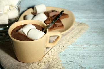 Fototapeta na wymiar Hot chocolate with marshmallows in mug, on wooden background