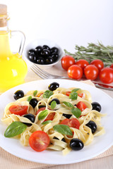 Obraz na płótnie Canvas Spaghetti with tomatoes, olives, olive oil and basil leaves