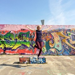 Mädchen springt vor Graffiti
