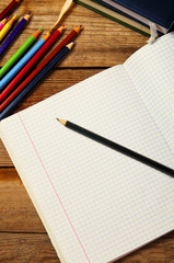 Blank paper and colorful pencils, on the wooden table.