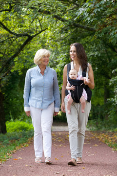 Mother walking outdoors with grandmother and baby