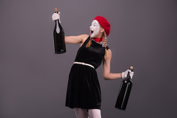Portrait of young mime girl holding big bottles in her hands iso