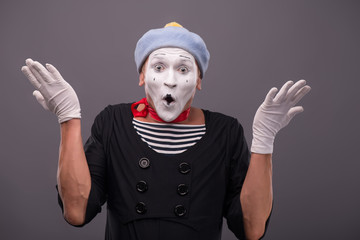 Portrait of young mime boy showing something with his hands