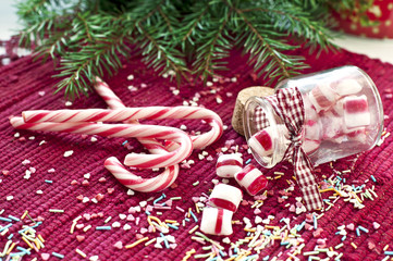 Sweet candies spilled/poured from glass jar. Green fir christmas