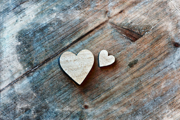 Obraz premium Two Wooden Hearts on Wooden Background