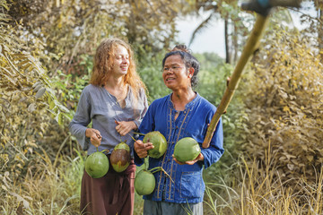 Asian man with  his young wife collecting coconuts