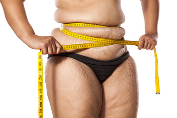 very fat woman measure her waist with tape