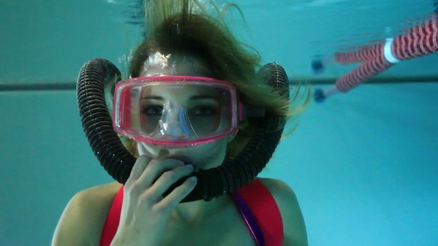 Female scuba diver playing with regulator