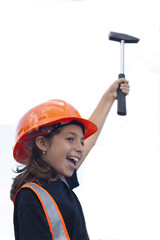Bambina con abiti di sicurezza cantiere e martello