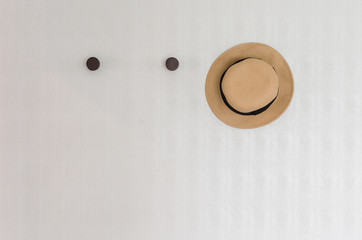 brown hat hanging on wall hook