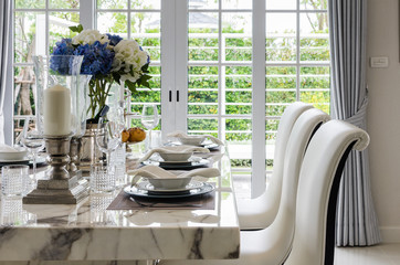 table set in white dinning room with chairs