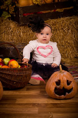 Fototapeta premium little baby girl on Halloween party with pumpkin