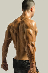 Bodybuilder showing his back,shoulders, triceps and biceps
