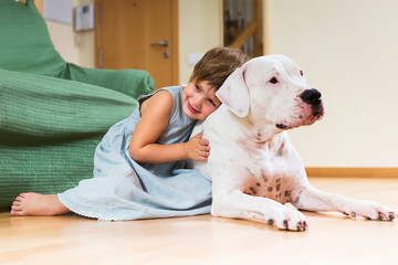 Little girl hugging white dog