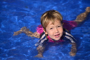 Fototapeta na wymiar Swimming lessons: Cute baby girl n the pool