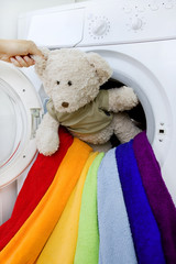 woman taking fluffy toy from washing machine