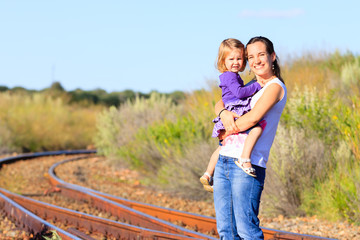 Mutter mit Kleinkind auf Bahngleisen