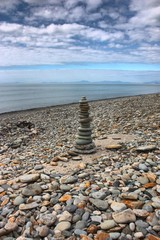 Fototapeta na wymiar stones balancing on top of each to make a tower on a beach