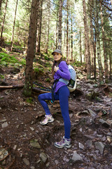 Woman with backpack hiking into the forest