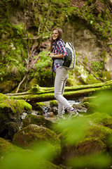Woman hiker crossing the river
