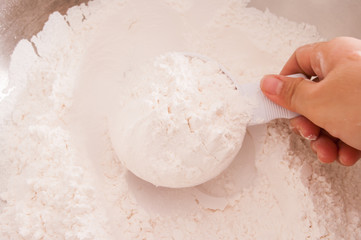 Close up of busy hands measuring flour