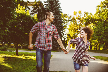 Fototapeta premium Happy couple in love running at alley. Toned image