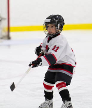 Child making a pass while playing ice hockey