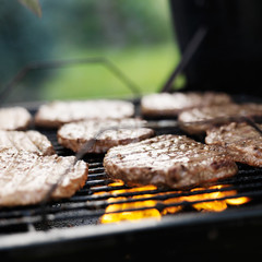 hamburgers grilling on charcoal grill