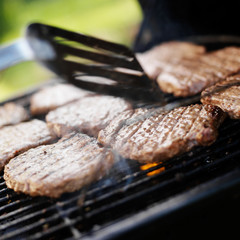 flipping over burgers on grill