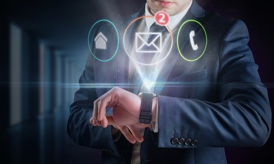 Composite image of businessman using hologram watch